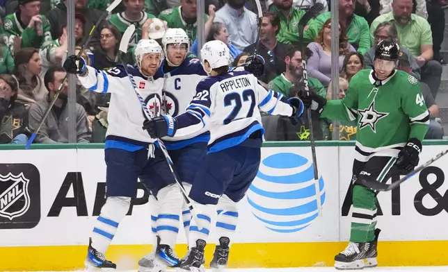 Winnipeg Jets right wing Nino Niederreiter, left, celebrates his first period goal with teammates center Adam Lowry, center, and center Mason Appleton of an NHL hockey game Thursday, April 10, 2025, in Dallas. (AP Photo/Julio Cortez)