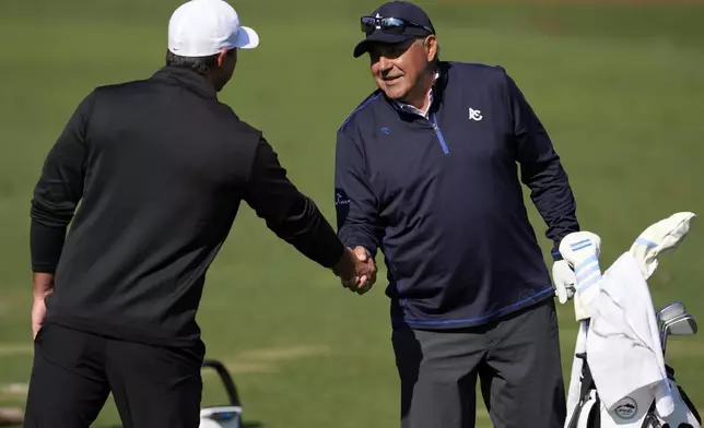 Brooks Koepka, left, and Angel Cabrera, of Argentina, meet on the range during a practice around at the Masters golf tournament, Wednesday, April 9, 2025, in Augusta, Ga. (AP Photo/George Walker IV)