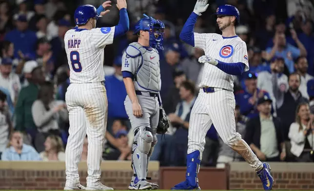 Chicago Cubs' Kyle Tucker (30), right, high fives Ian Happ after Tucker hit a two-run home run during the eighth inning of a baseball game against the Los Angeles Dodgers, Tuesday, April 22, 2025, in Chicago. (AP Photo/Erin Hooley)