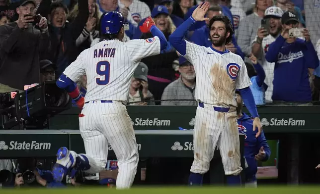 Chicago Cubs' Dansby Swanson, right, high-fives Miguel Amaya (9) after Amaya hit a game-tying home run during the ninth inning of a baseball game against the Los Angeles Dodgers, Tuesday, April 22, 2025, in Chicago. (AP Photo/Erin Hooley)