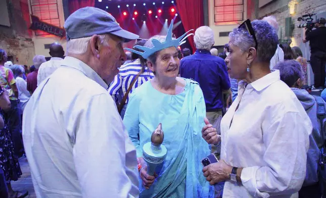 Karen Mallam, dress as lady liberty, talks at a Democratic town hall at the Haw River Ball Room in Saxapahaw, N.C., Thursday, April 24, 2025. (AP Photo/Allen G. Breed)
