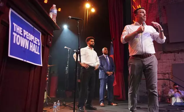 Sen. Chris Murphy, D-Conn., speaks from the stage of the Haw River Ball Room during a town hall in Saxapahaw, N.C., Thursday, April 24, 2025, as Rep. Maxwell Frost, D-Fla., left, listens. (AP Photo/Allen G. Breed)