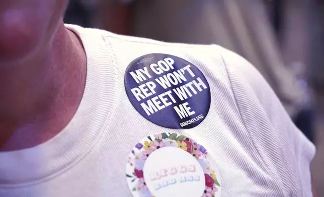 A woman wears a sticker saying "My GOP Rep Won't Meet With Me" during a town hall at the Haw River Ball Room in Saxapahaw, N.C., Thursday, April 24, 2025. (AP Photo/Allen G. Breed)