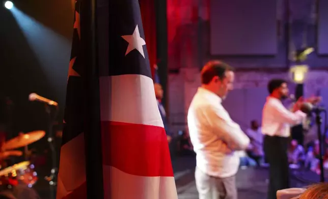 Rep. Maxwell Frost, D-Fla., speaks from the stage of the Haw River Ball Room during a town hall in Saxapahaw, N.C., Thursday, April 24, 2025, as Sen. Chris Murphy, D-Conn., listens at left. (AP Photo/Allen G. Breed)