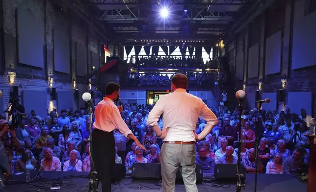 Rep. Maxwell Frost, D-Fla., speaks from the stage of the Haw River Ball Room during a town hall in Saxapahaw, N.C., Thursday, April 24, 2025, as Sen. Chris Murphy, D-Conn., right, listens. (AP Photo/Allen G. Breed)