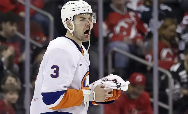 New York Islanders defenseman Adam Pelech (3) yells after being hit by New Jersey Devils center Paul Cotter in the second period of an NHL hockey game Sunday, April 13, 2025, in Newark, N.J. (AP Photo/Adam Hunger)