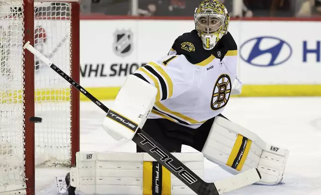 Boston Bruins goaltender Jeremy Swayman watches a shot go wide of the net in the second period of an NHL hockey game against the New Jersey Devils, Tuesday, April 8, 2025, in Newark, N.J. (AP Photo/Adam Hunger)