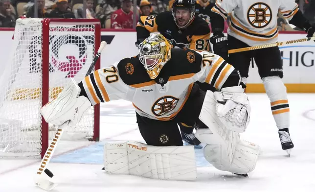 Boston Bruins goaltender Joonas Korpisalo (70) tries to control a rebound during the second period of an NHL hockey game against the Pittsburgh Penguins in Pittsburgh, Sunday, April 13, 2025. (AP Photo/Gene J. Puskar)