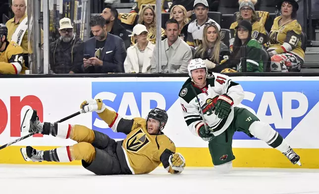 Vegas Golden Knights defenseman Brayden McNabb (3) and Minnesota Wild center Gustav Nyquist (41) fall to the ice during the third period of Game 2 of a first-round NHL hockey playoff series Tuesday, April 22, 2025, in Las Vegas. (AP Photo/David Becker)