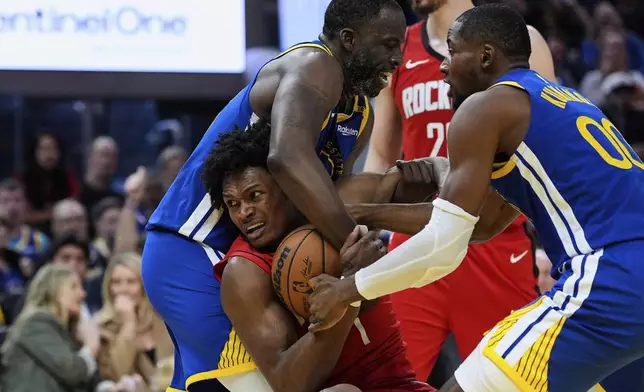 Houston Rockets forward Amen Thompson (1) and Golden State Warriors forward Draymond Green , left, compete for possession of the ball during the second half of an NBA basketball game Sunday, April 6, 2025, in San Francisco. (AP Photo/Godofredo A. Vásquez)