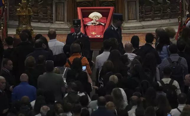 People line up to pay their respects to Pope Francis lying in state, inside St. Peter's Basilica, at the Vatican, Friday, April 25, 2025. (AP Photo/Andrew Medichini)