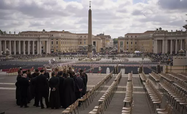 Priests and security personnel gather outside St. Peter's Basilica where Pope Francis lying in state, at the Vatican, Friday, April 25, 2025. (AP Photo/Emilio Morenatti)