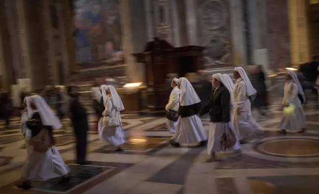 Nuns walk at St. Peter's Basilica where Pope Francis is lying in state, at the Vatican, Friday, April 25, 2025. (AP Photo/Emilio Morenatti)
