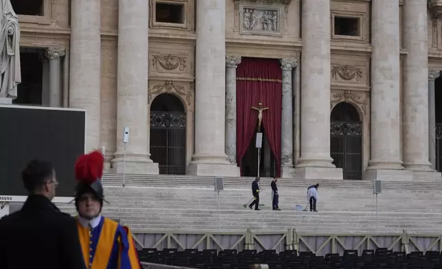 Workers clean the steps at the St. Peter's Square ahead of the arrival of the body of Pope Francis, who will lie in state at St. Peter's Basilica for three days, at the Vatican, Wednesday, April 23, 2025. (AP Photo/Gregorio Borgia)