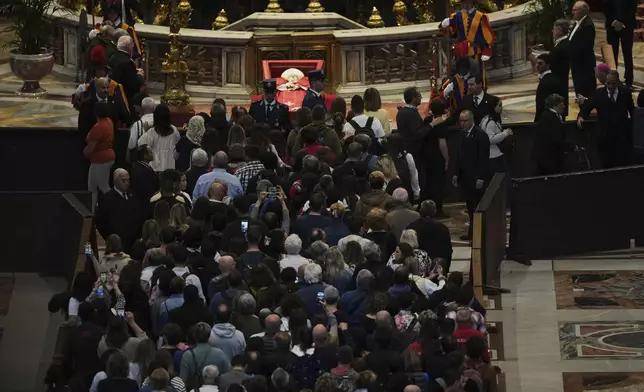 People line up to pay their respects to Pope Francis lying in state, inside St. Peter's Basilica, at the Vatican, Friday, April 25, 2025. (AP Photo/Andrew Medichini)