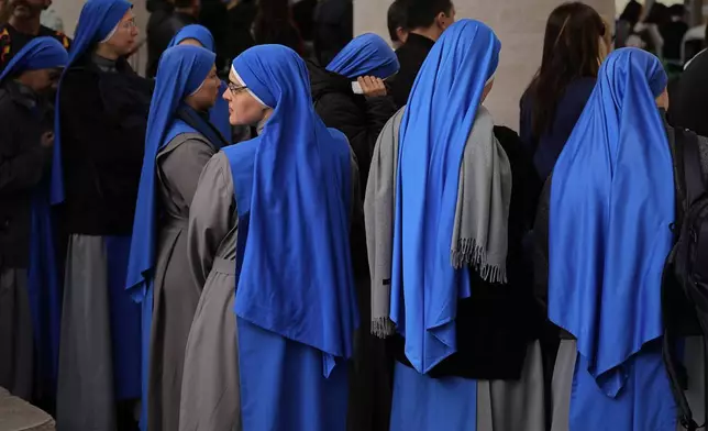 Nuns wait in St. Peter's Square to pay their respects to the late Pope Francis, lying in state at St. Peter's Basilica for the final day, at the Vatican, Friday, April 25, 2025. (AP Photo/Andreea Alexandru)