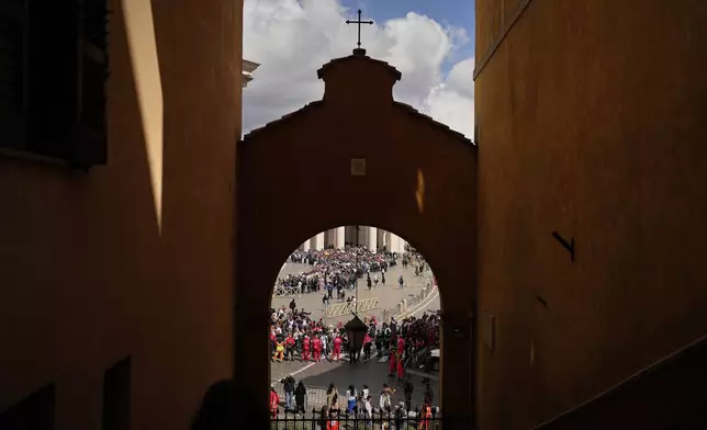 People wait in St. Peter's Square to pay their respects to the late Pope Francis, lying in state at St. Peter's Basilica for the final day, at the Vatican, Friday, April 25, 2025. (AP Photo/Andreea Alexandru)