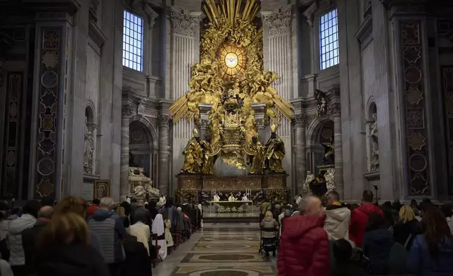Priests celebrate mass at St. Peter's Basilica where Pope Francis lying in state, at the Vatican, Friday, April 25, 2025. (AP Photo/Emilio Morenatti)