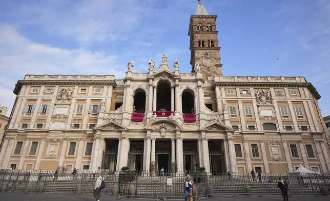 Andrea, a tourist from Freiburg, Germany, poses for a friend along with Kaya, the dog, in front of the Santa Maria Maggiore Basilica, where the late Pope Francis will be buried, in Rome, Thursday, April 24, 2025. (AP Photo/Andreea Alexandru)