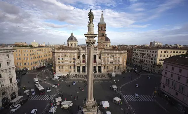 People walk next to the Santa Maria Maggiore Basilica, where the late Pope Francis will be buried, in Rome, Thursday, April 24, 2025. (AP Photo/Andreea Alexandru)