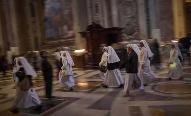 Nuns walk at St. Peter's Basilica where Pope Francis lying in state, at the Vatican, Friday, April 25, 2025. (AP Photo/Emilio Morenatti)