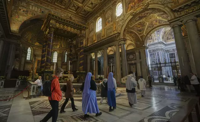 Faithful and nuns walk inside in St. Mary Major basilica, where Pope Francis will be buried, in Rome, Tuesday, April 22, 2025. (AP Photo/Alessandra Tarantino)