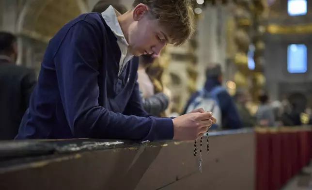 Faithful pray at St. Peter's Basilica where Pope Francis lying in state, at the Vatican, Friday, April 25, 2025. (AP Photo/Emilio Morenatti)