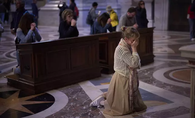 Faithful pray at St. Peter's Basilica where Pope Francis lying in state, at the Vatican, Friday, April 25, 2025. (AP Photo/Emilio Morenatti)
