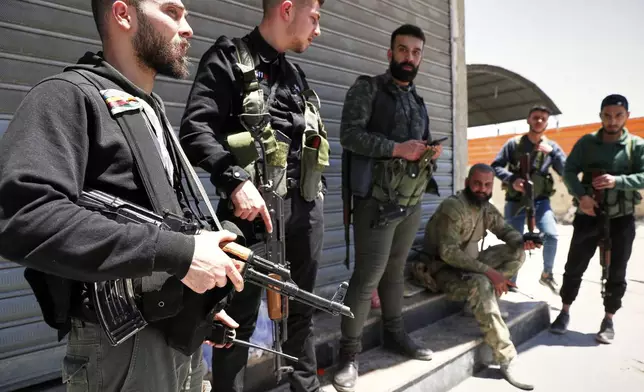 Druze gunmen stand next to a checkpoint a day after clashes between members of the minority Druze sect and pro-government fighters left at least four people dead in the southern suburb of Jaramana, Damascus, Syria, Tuesday, April 29, 2025. (AP Photo/Omar Sanadiki)