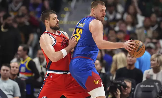 Denver Nuggets center Nikola Jokic, right, looks to pass the ball as Los Angeles Clippers center Ivica Zubac, left, defends in the second half of Game 1 of an NBA first-round playoff series Saturday, April 19, 2025, in Denver. (AP Photo/David Zalubowski)