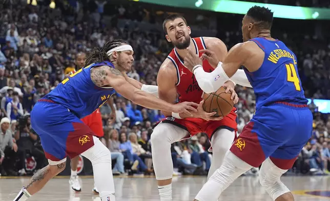 Los Angeles Clippers center Ivica Zubac, center, goes up for a basket between Denver Nuggets forward Aaron Gordon, left, and guard Russell Westbrook in the second half of Game 1 of an NBA first-round playoff series Saturday, April 19, 2025, in Denver. (AP Photo/David Zalubowski)