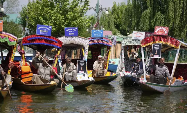 Kashmiri boatmen hold placards as they condemn the tourists killing at Dal Lake in Srinagar, Indian controlled Kashmir, Thursday, April. 24, 2025. (AP Photo/Mukhtar Khan)