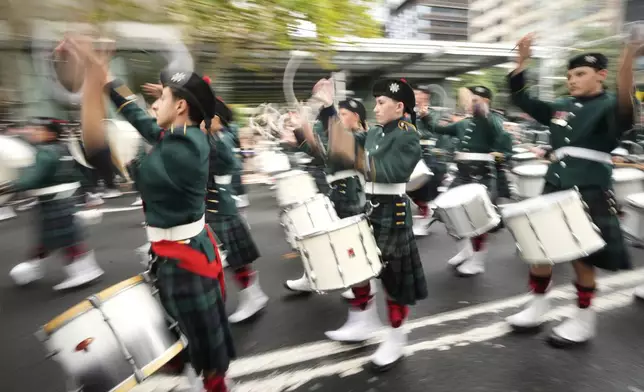 A band marches by as thousands of people line the street to pay tribute to their war dead on Anzac Day in Sydney, Australia, Friday, April 25, 2025. (AP Photo/Rick Rycroft)