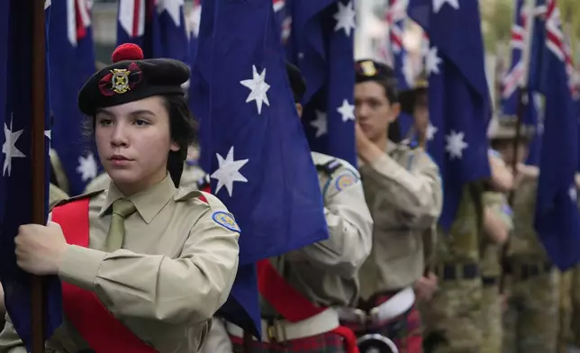 Cadets carrying Australian flags march past thousands of people lining the street to pay tribute to their war dead during the Anzac Day parade in Sydney, Australia, Friday, April 25, 2025. (AP Photo/Rick Rycroft)
