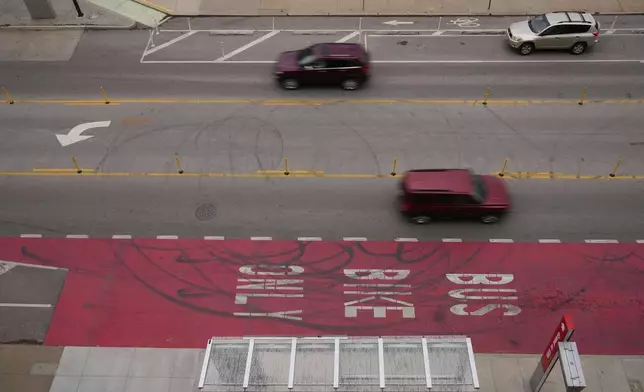 Cars drive on Grand Boulevard in Kansas City, Mo., where the city implemented a "road diet" reducing the street from four lanes to two in an effort to reduce speeding and accidents, Thursday, April 17, 2025. (AP Photo/Charlie Riedel)
