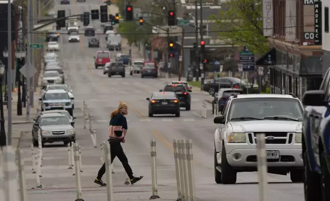 A man crosses 31st Street in Kansas City, Mo., where the city implemented a "road diet" reducing the street from four lanes to two in an effort to reduce speeding and accidents, Thursday, April 17, 2025. (AP Photo/Charlie Riedel)