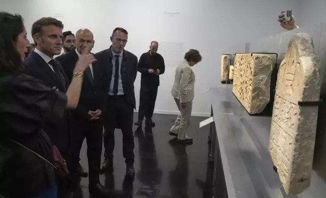 French President Emmanuel Macron, second left, listens to explanations as he visits the exhibition "Treasures rescued from Gaza" Monday, April 14, 2025 at the Arab World Institute (IMA) in Paris. (AP Photo/Michel Euler, Pool)