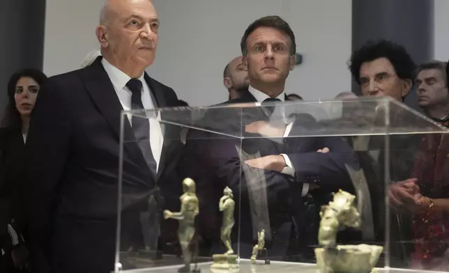 French President Emmanuel Macron, center, and Hani al-Hayek, left, the Palestinian Authority's minister for heritage and tourism, visit the exhibition "Treasures rescued from Gaza" Monday, April 14, 2025 at the Arab World Institute (IMA) in Paris. (AP Photo/Michel Euler, Pool)