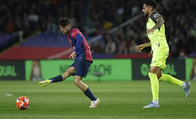 Barcelona's Pedri, right, passes the ball past Mallorca's Omar Mascarell during a Spanish La Liga soccer match between Barcelona and Mallorca at the Lluis Companys Olympic stadium in Barcelona, Spain, Tuesday, April 22, 2025. (AP Photo/Joan Monfort)