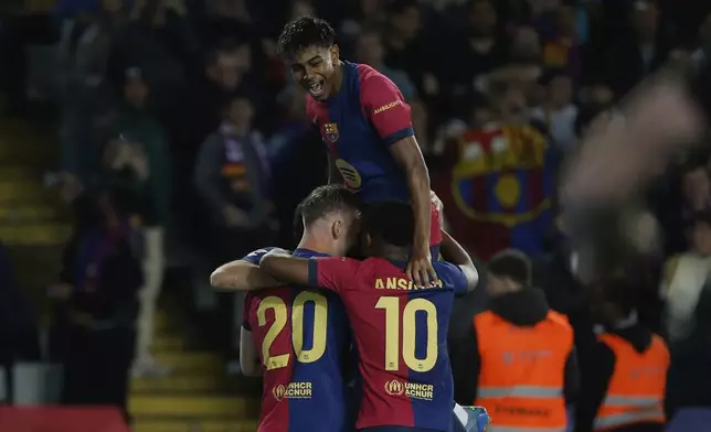 Barcelona's Dani Olmo, left, celebrates with his teammates after scoring his side's opening goal during a Spanish La Liga soccer match between Barcelona and Mallorca at the Lluis Companys Olympic stadium in Barcelona, Spain, Tuesday, April 22, 2025. (AP Photo/Joan Monfort)