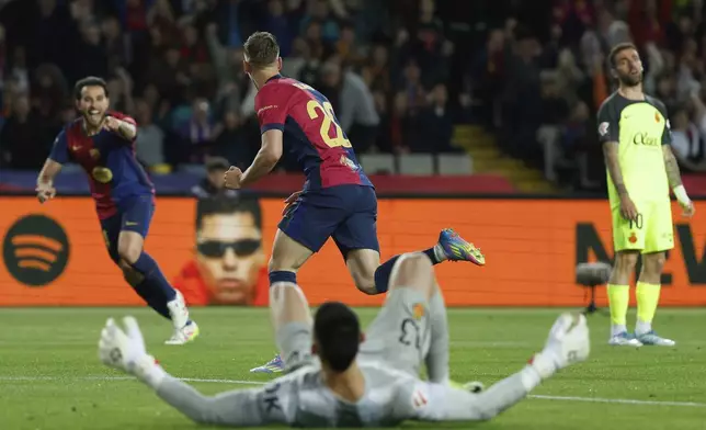 Barcelona's Dani Olmo, center, celebrates with scoring his side's opening goal during a Spanish La Liga soccer match between Barcelona and Mallorca at the Lluis Companys Olympic stadium in Barcelona, Spain, Tuesday, April 22, 2025. (AP Photo/Joan Monfort)