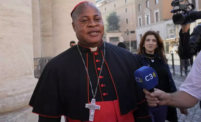 Cardinal Peter Ebere Okpaleke is approached by reporters as he arrives for a college of cardinals' meeting, at the Vatican, Wednesday, April 30, 2025. (AP Photo/Gregorio Borgia)