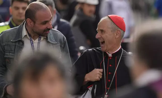 Cardinal Jean-Paul Vesco, right, reacts to a reporter's question as he arrives for a college of cardinals' meeting, at the Vatican, Friday, April 25, 2025. (AP Photo/Gregorio Borgia)