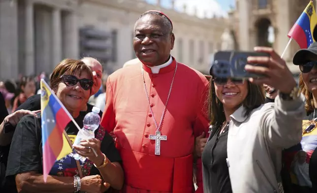 Cardinal John Olorunfemi Onaiyekan, of Nigeria, poses for photos with a group from Venezuela after the funeral of Pope Francis in St. Peter's Square at the Vatican, Saturday, April 26, 2025. (AP Photo/Andrew Medichini)