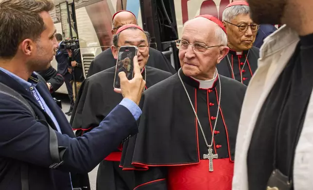 A journalist scans with his smartphone Cardinal Fernando Filoni outside St. Mary Major Basilica in Rome, Sunday, April 27, 2025. (AP Photo/Bernat Armangue)