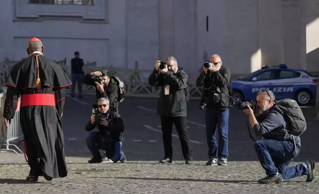 Photographers take pictures of a cardinal as he arrives for a college of cardinals' meeting, at the Vatican, Wednesday, April 30, 2025. (AP Photo/Gregorio Borgia)