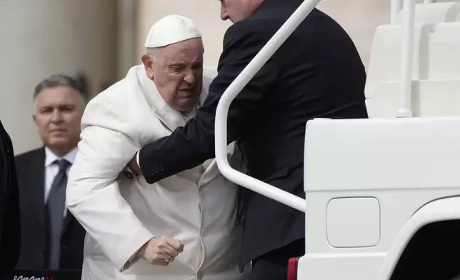 FILE - Pope Francis helped to get on his car at the end of weekly general audience in St. Peter's Square, at the Vatican, Wednesday, March 29, 2023. (AP Photo/Alessandra Tarantino, File)