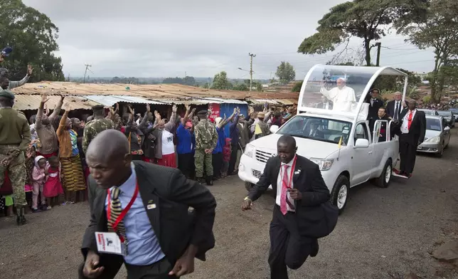FILE - Pope Francis waves to local residents as he drives to St. Joseph The Worker Catholic Church in the Kangemi slum of Nairobi, Kenya Friday, Nov. 27, 2015. (AP Photo/Ben Curtis, file)