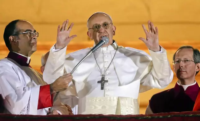 FILE - Argentine Cardinal Jorge Bergoglio, who chose the name of Pope Francis, waves to the crowd from the central balcony of St. Peter's Basilica after being elected 266th pontiff of the Roman Catholic Church, at the Vatican, Wednesday, March 13, 2013. (AP Photo/Gregorio Borgia, file)