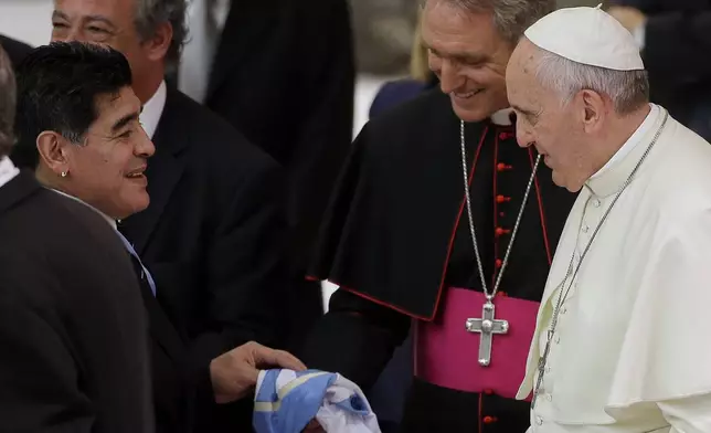 FILE - Argentine soccer legend Diego Armando Maradona, left, greets Pope Francis in the Paul VI hall at the Vatican, Sept. 1, 2014. (AP Photo/Gregorio Borgia, File)